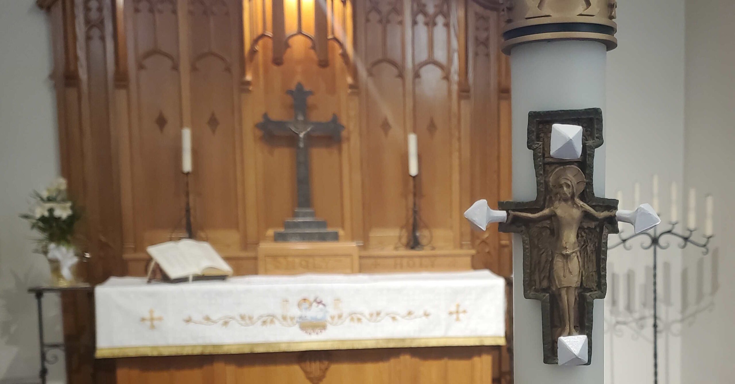 Closeup of Paschal Candle with altar in background. These are worship adornments.